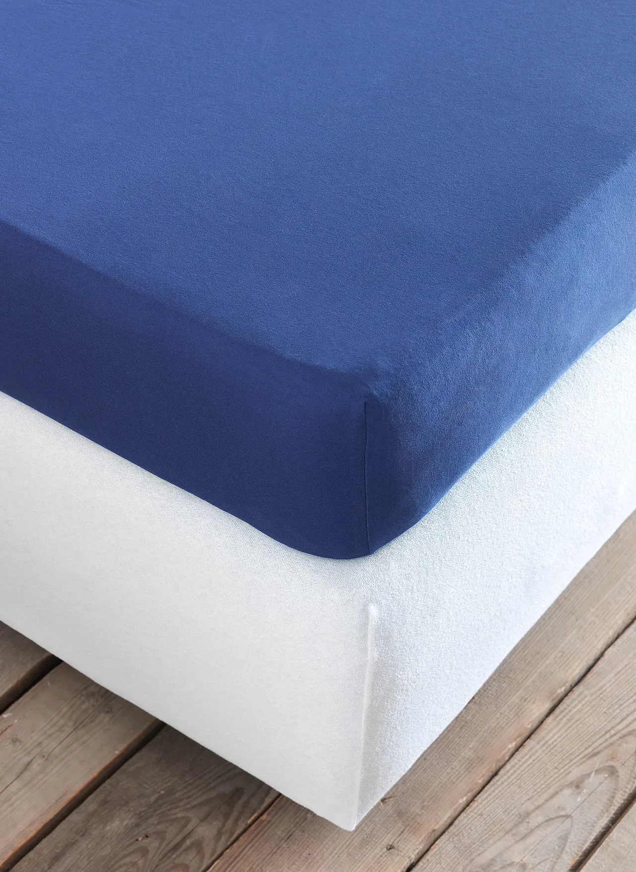 Navy fitted sheet on a mattress