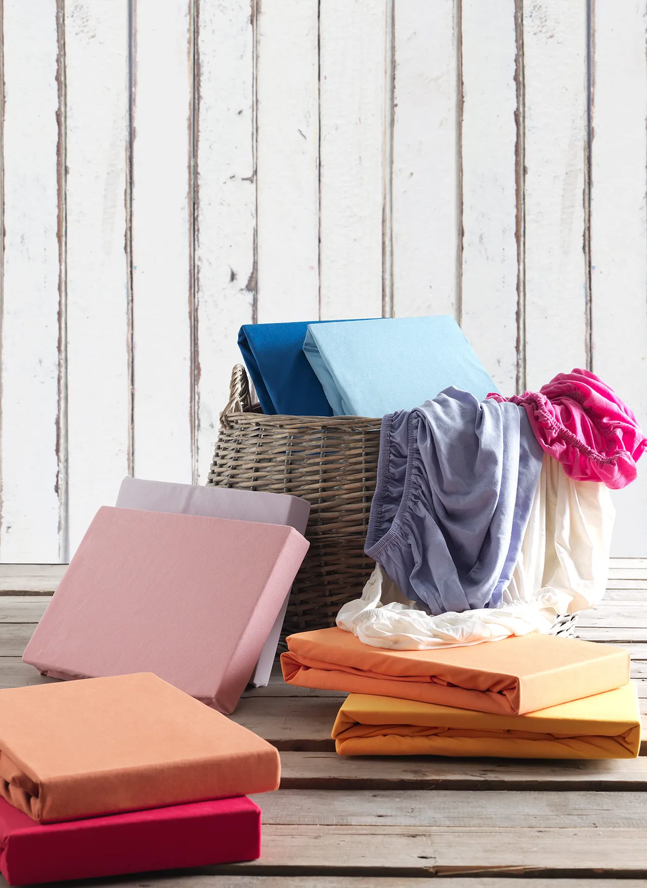 Folded fitted sheets in pink, orange, turquoise and other colours