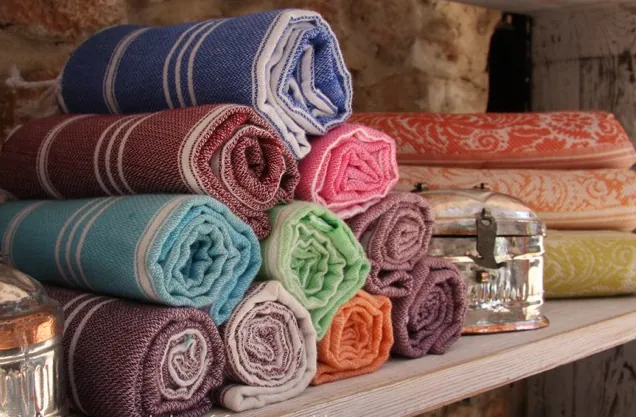 Rolled striped peshtemals in blue, pink, turquoise and orange