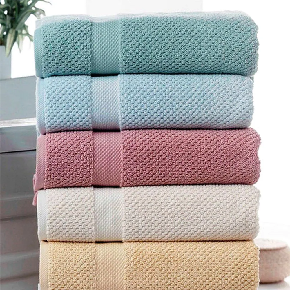 Stack of honeycomb-weave cotton towels in teal, blue, pink, cream and yellow