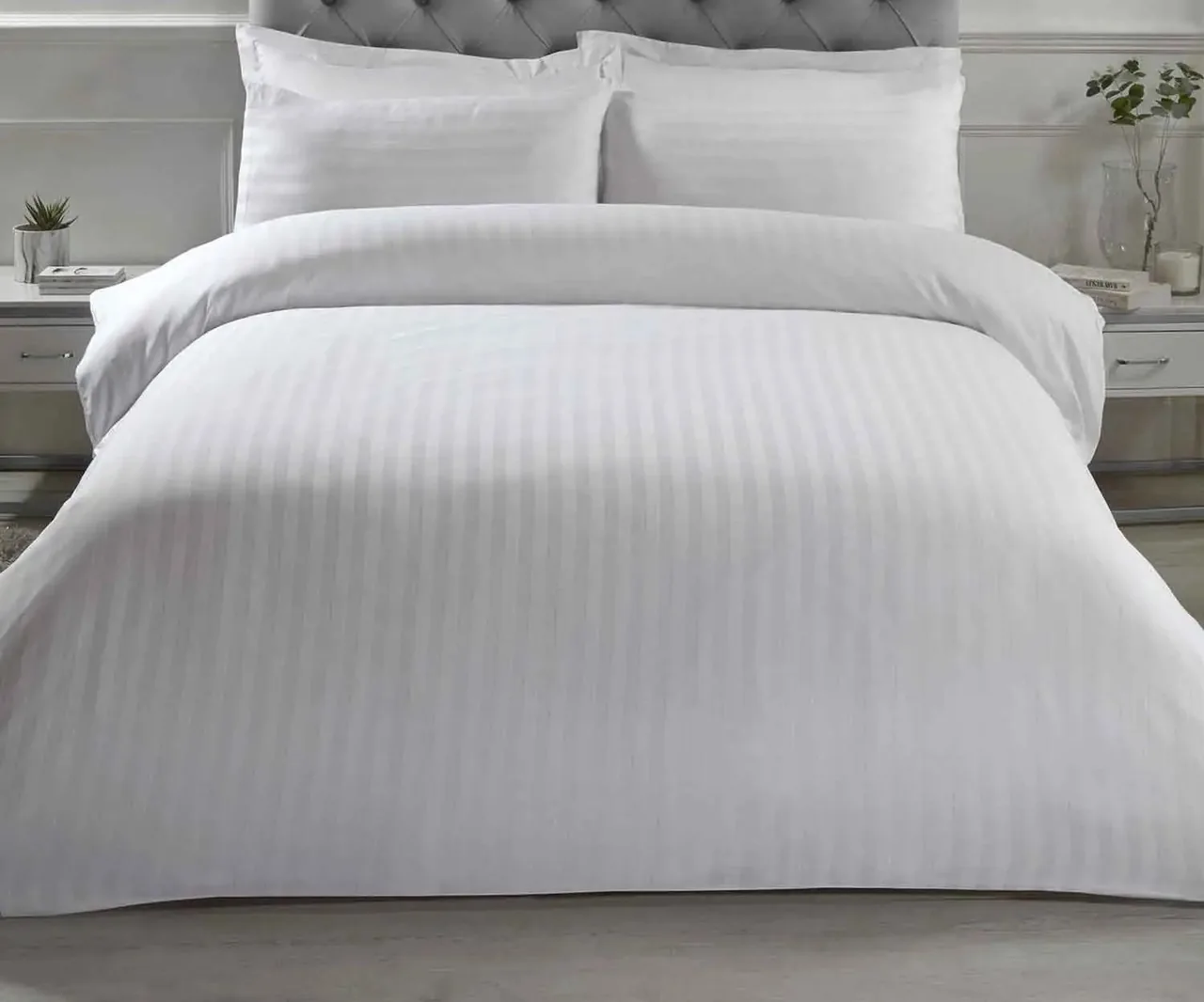 Bed made up with a white stripe satin duvet cover and pillowcases