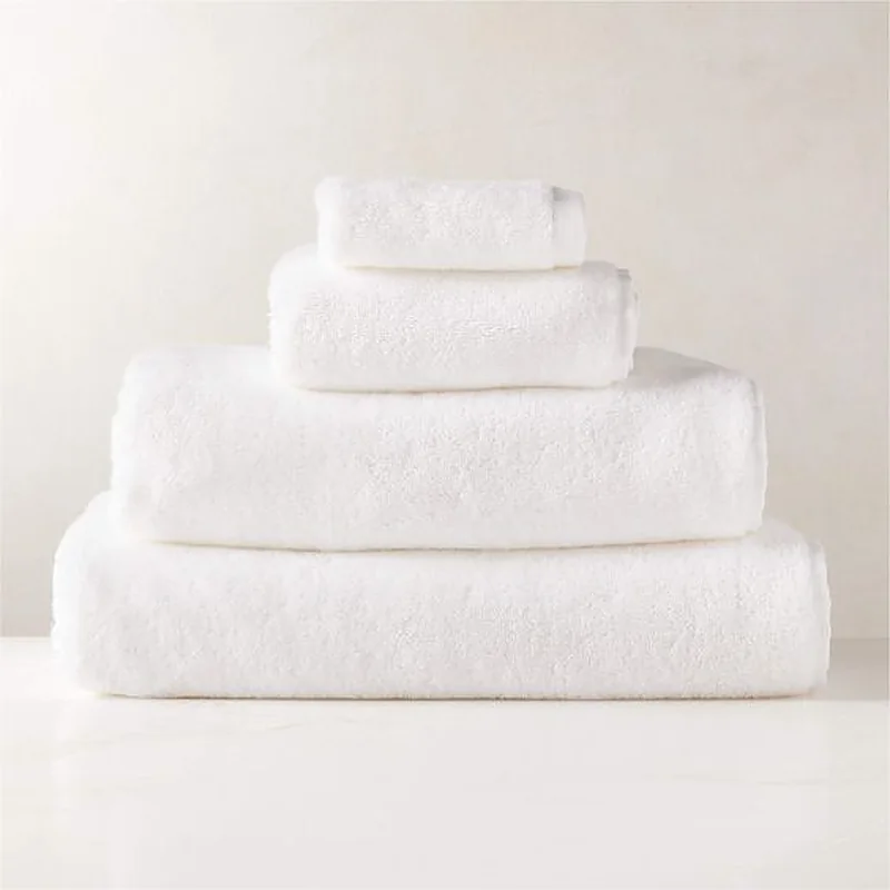Stack of four white terry towels in graduated sizes